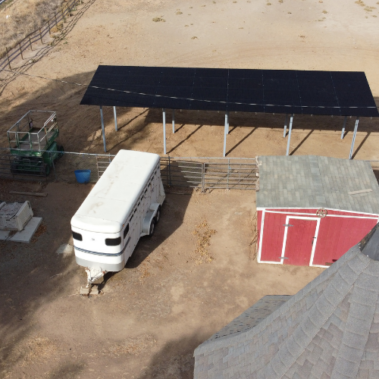 Ground Mounted Solar Panel aerial - view of solar panels with small shed and large trailer.