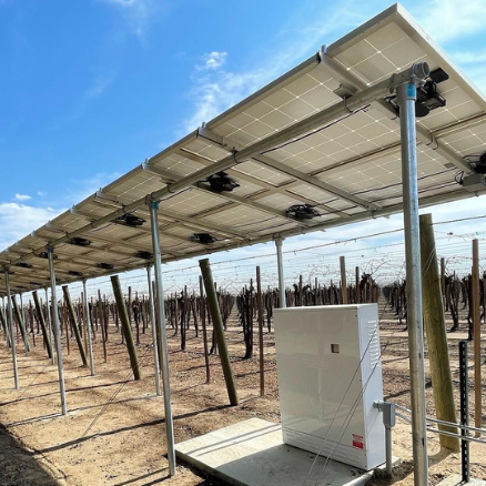 Ground Mount Solar Installation - A blue sky is above an outdoor solar panel in an agricultural field, along with electrical box.