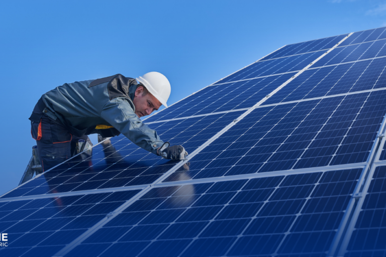 The Latest Solar Panel Technology in 2025 - a solar technician wears a hard hat and checks the solar panels he is working on.