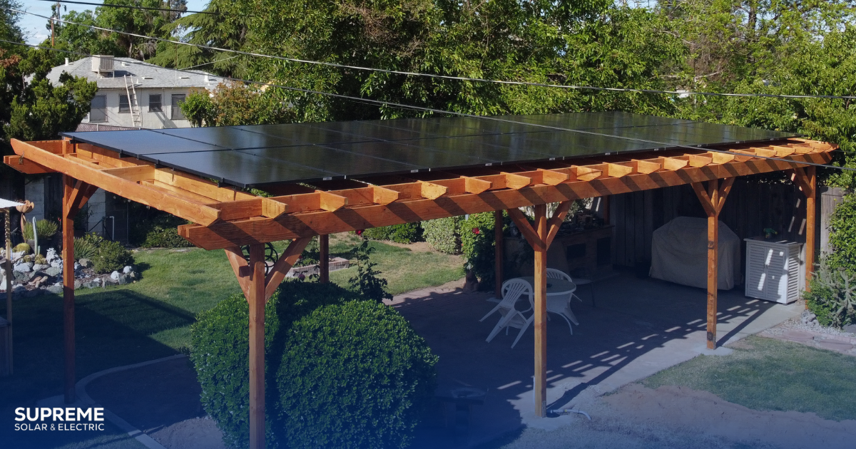 Why are all your neighbors getting solar patio covers? A pergola patio in a back yard has solar panels on top.