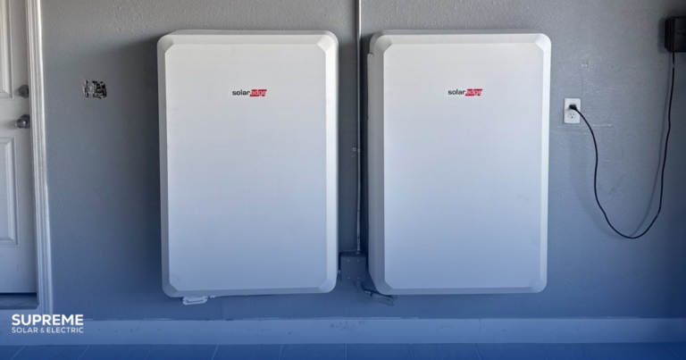 How to Choose the Right Solar Battery for Your Home: two solar batteries mounted on a garage wall.