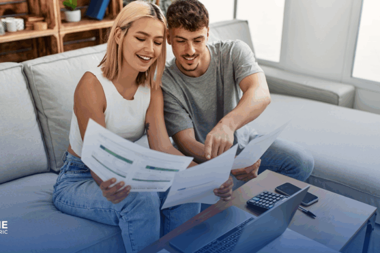 young couple sits on couch and looks over financials