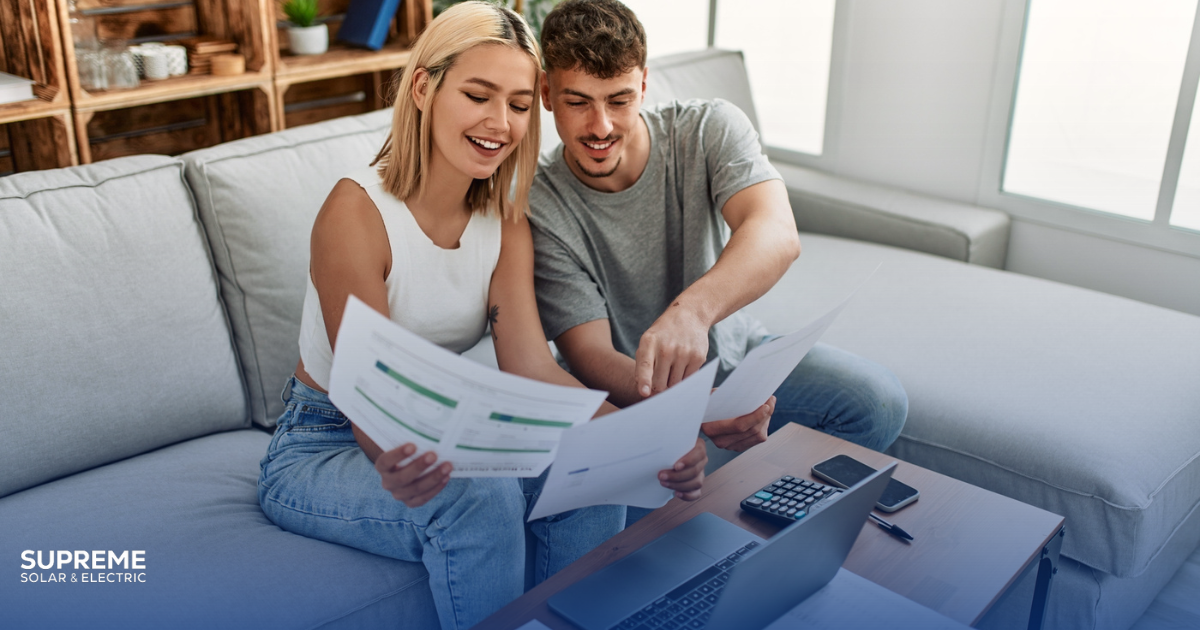 How Much Can You Save Breaking Down Solar Energy Savings for Fresno Homes young couple sits on couch and looks over financials